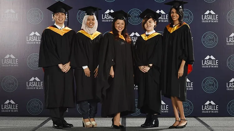 Un grupo de graduados se encuentra delante del logotipo del Great Lakes College of Toronto.