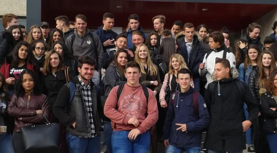 Un grande gruppo di studenti e studentesse si riunisce all'interno dell'edificio del Lycée Gabriel Fauré.