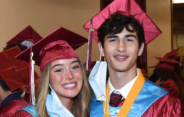 Dos graduados de la Scecina Memorial High School con togas posan juntos en la ceremonia de graduación.