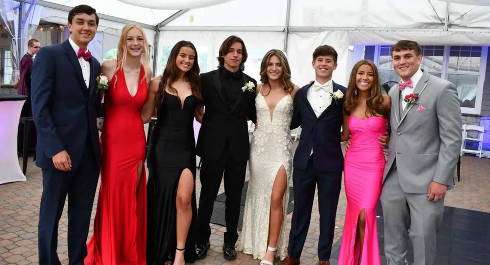 Un gruppo di studenti e studentesse ben vestiti durante una festa nel campus della Our Lady’s Secondary School.