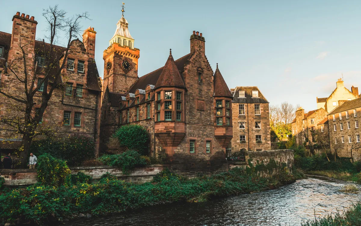 Casas históricas de Dean Village en Edimburgo junto al río, con la torre del reloj