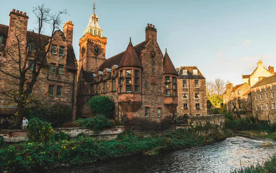 Casas históricas de Dean Village en Edimburgo junto al río, con la torre del reloj