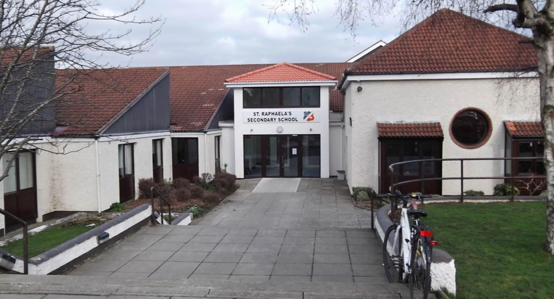 L'edificio della St. Raphaela’s Secondary School con un tetto di tegole rosse e una bicicletta davanti all'ingresso.