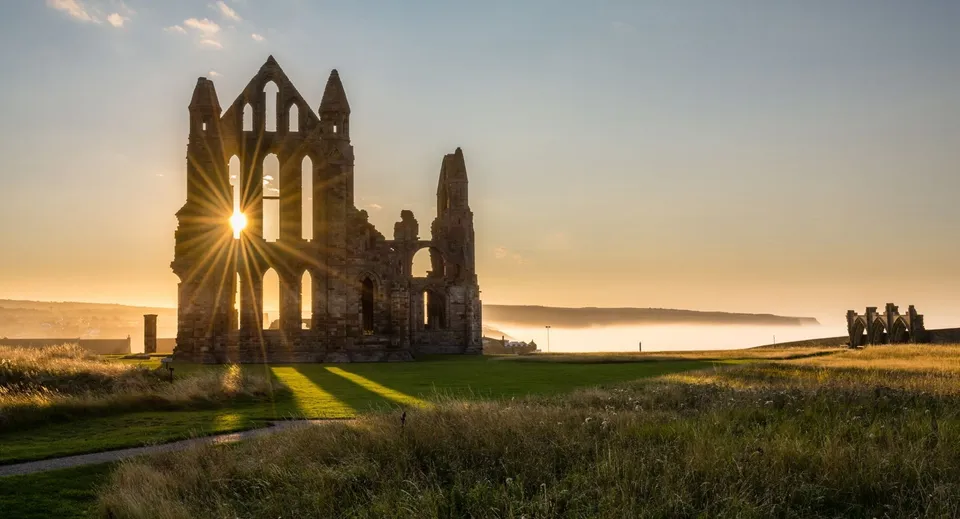 Le rovine di un'abbazia immerse nel paesaggio all'interno del campus della Rossall School baciate dalla luce del sole.