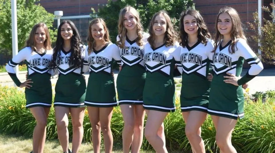 Un gruppo di giovani cheerleader posa all'aperto nel campus della Lake Orion High School.