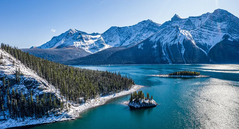Un paesaggio pittoresco con montagne innevate e un lago turchese vicino alla St. Mother Teresa High School.