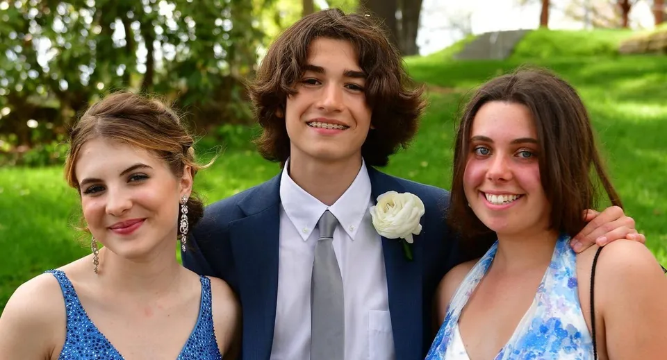 Tre studenti della Frederick Gunn School posano insieme sorridenti in un'area verde all'aperto.