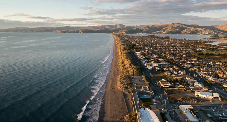 Vista sul paesaggio costiero con spiaggia e montagne vicino alla Pukekohe High School.