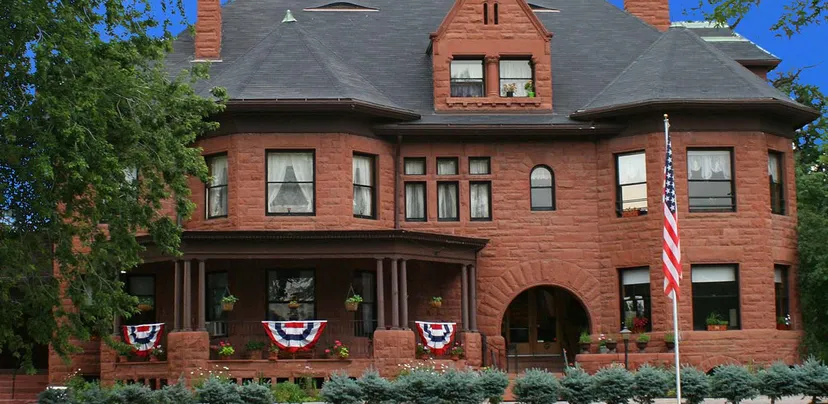 Il storico edificio in mattoni della Accelerated School è circondato da vegetazione verde e decorato con decorazioni patriottiche.