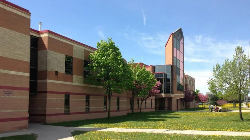 L'edificio moderno a più piani della Resurrection Catholic School è immerso in un paesaggio verdeggiante con alberi e prati.