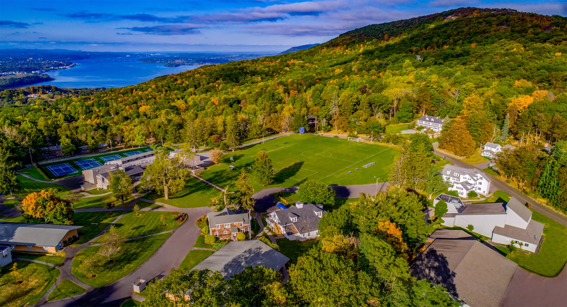 Paesaggio boschivo colorato con colline e acqua sullo sfondo presso la The Storm King School.