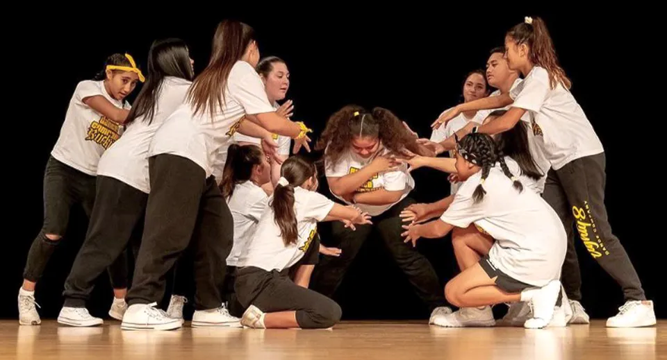 Un gruppo di ballerini si esibisce sul palco in una dinamica performance di danza nel campus della Springfield Central State High School.