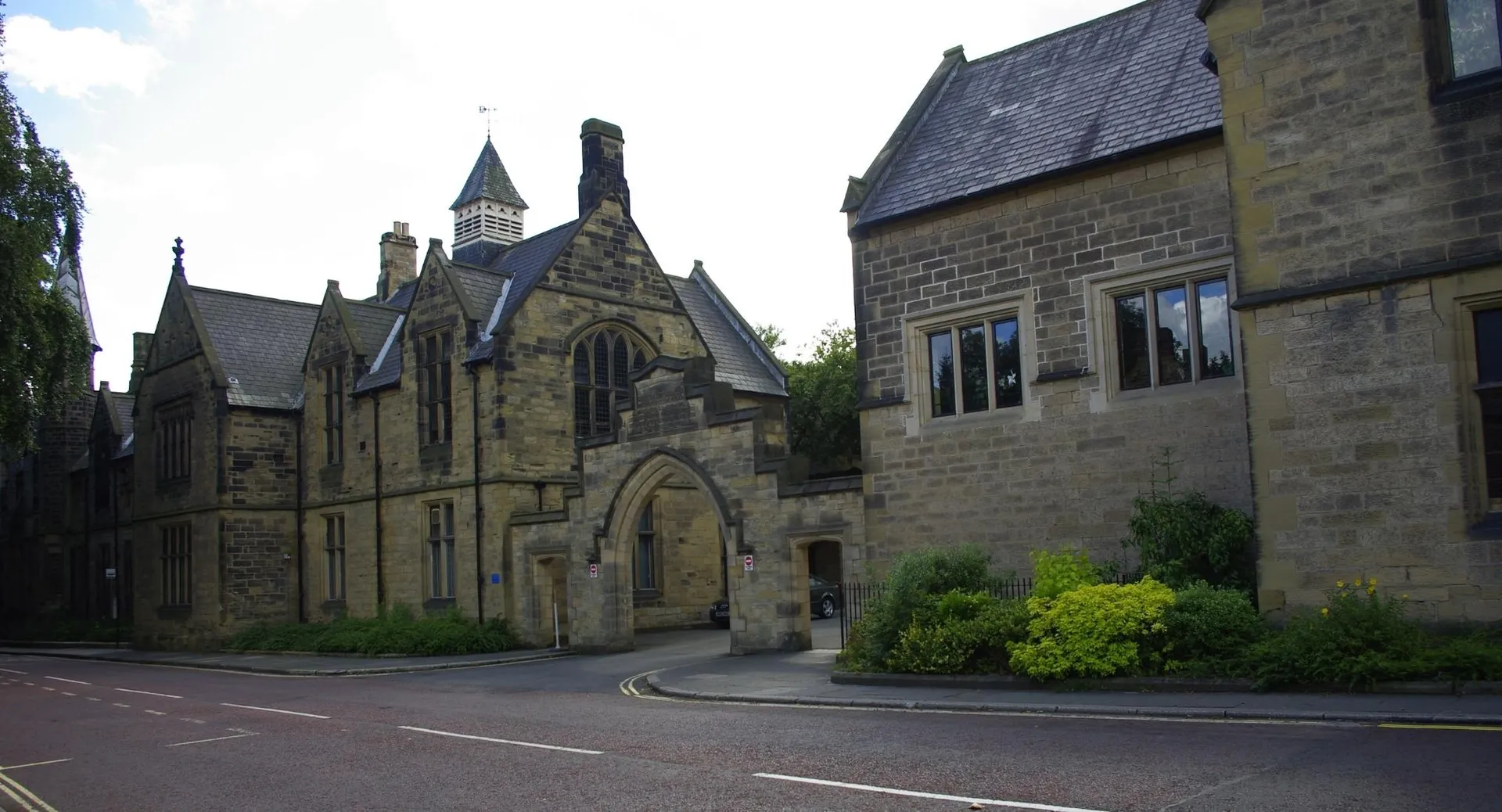 L'edificio principale storico in pietra della Durham School, con un'alta torre e un'architettura riccamente decorata, è circondato da alberi.