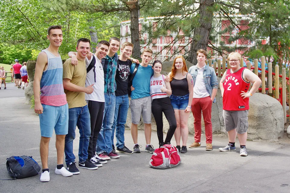 Un gruppo di studenti si trova sulla strada davanti ad edifici ed alberi nel campus della Mount Baker Secondary School.