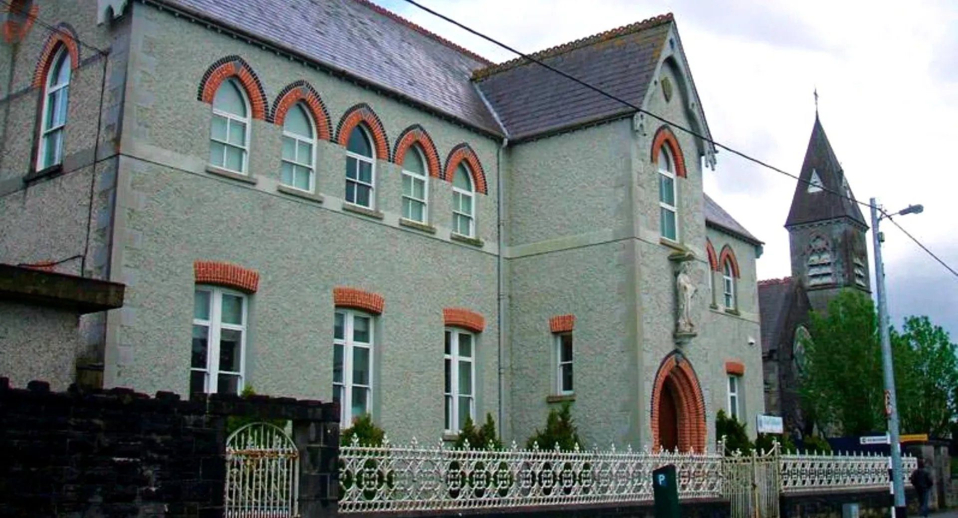 L'edificio della Meán Scoil Mhuire Longford presenta una facciata in mattoni decorata con alte finestre e una torre.