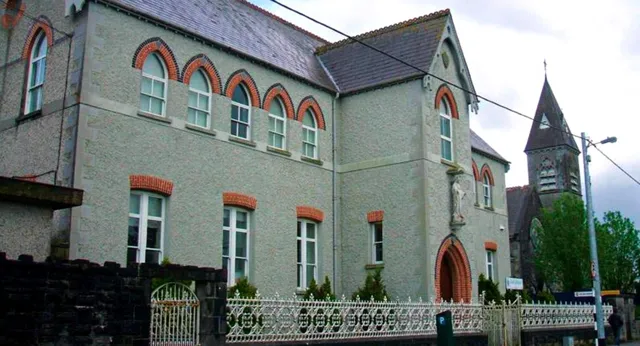 L'edificio della Meán Scoil Mhuire Longford presenta una facciata in mattoni decorata con alte finestre e una torre.