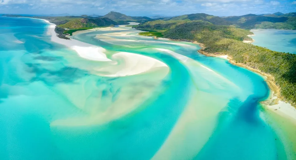 Una vista aerea mostra un paesaggio tropicale con spiagge di sabbia bianca e acque turchesi vicino al Hillcrest Christian College.