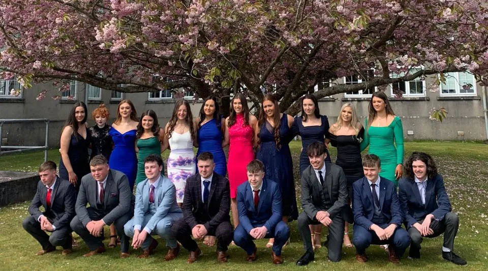 Un gruppo di studenti della Colaiste Mhuire (Tourmakeady) davanti a un ciliegio in fiore.
