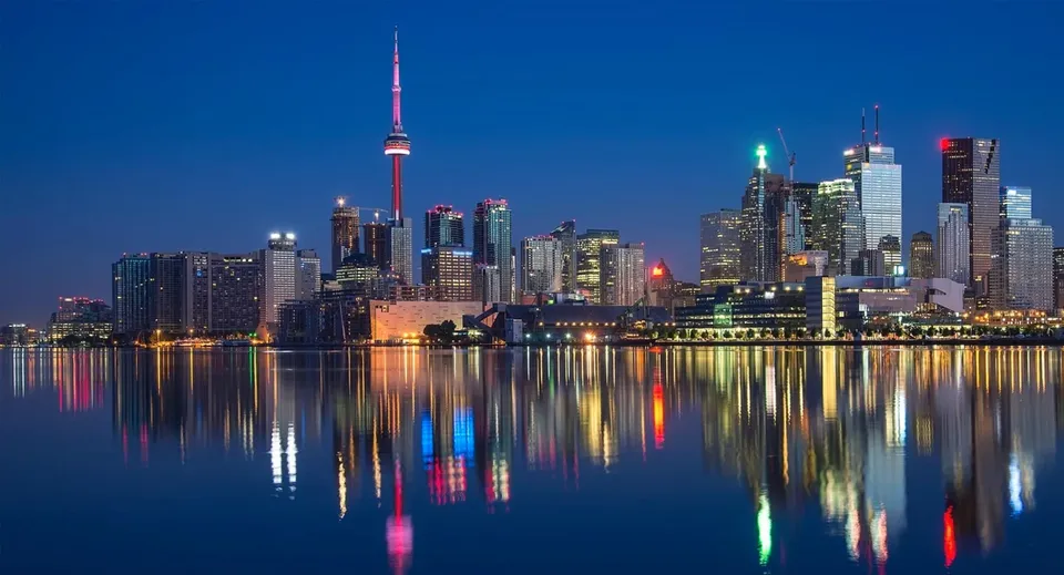 Skyline illuminata di una città con grattacieli riflettenti davanti alla Georgian Bay District Secondary School.