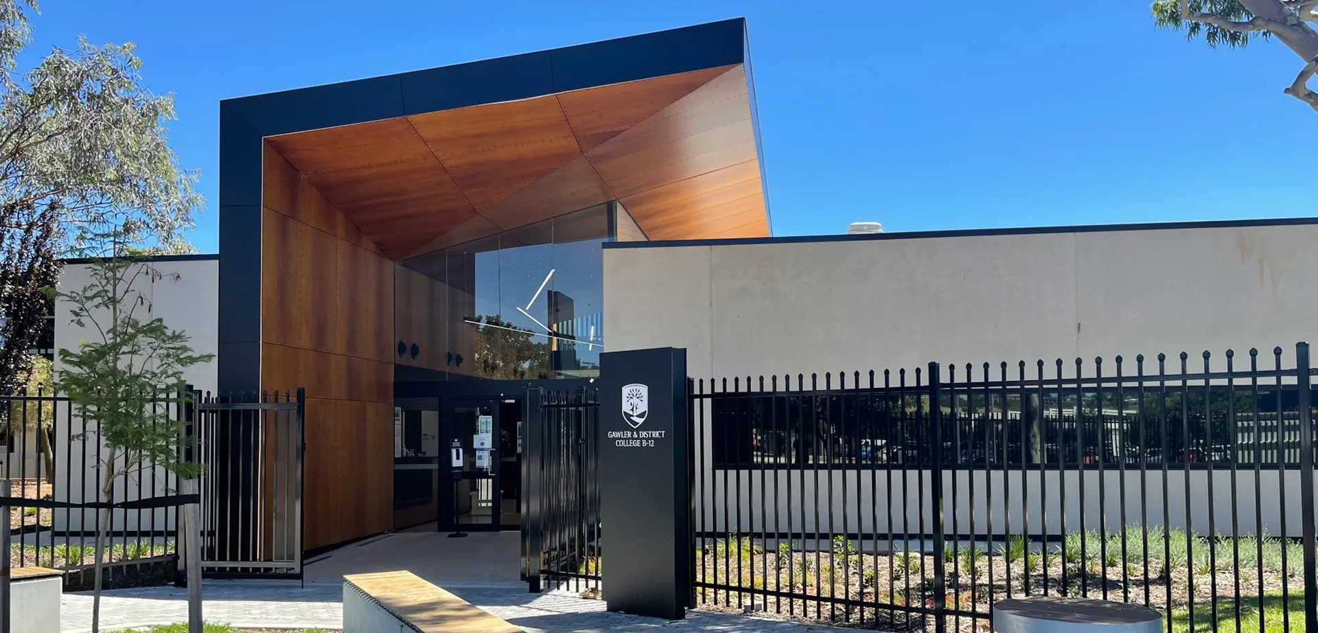 L'edificio moderno del Gawler and District College con balcone in legno e recinzione metallica sotto un cielo limpido.