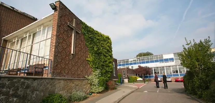 Si vede l'edificio in mattoni della Archbishop's School con un giardino verticale sulla facciata e un contesto moderno.