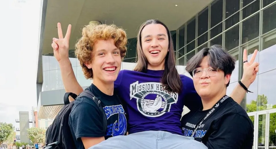 Tre studenti mostrano il segno della pace con le mani nel campus della Mission Heights Preparatory High School.