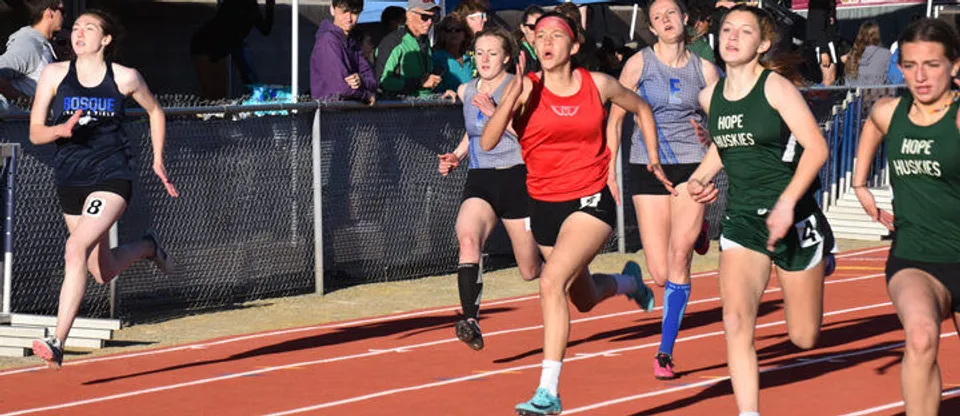 Atlete della Menaul School e di altre scuole gareggiano in una corsa di atletica sulla pista.