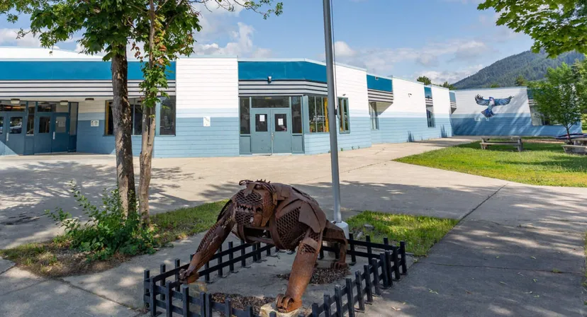 Una scultura in metallo arrugginito di un cavallo si trova davanti all'edificio della Creston Valley Secondary School.