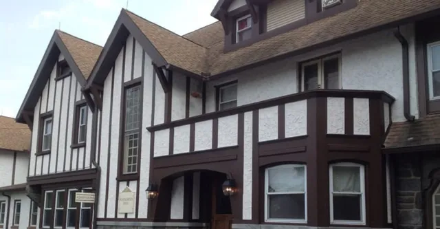 L'edificio stile Tudor a più piani con facciata esterna in legno e finestre a bow window nel campus della The Phelps School.