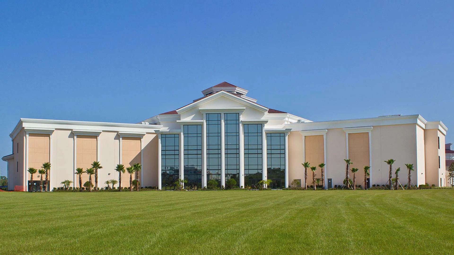 L'edificio principale moderno della Faith Christian Academy in Florida sorge su un prato curato sotto un cielo limpido.