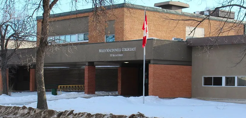 L'edificio in mattoni con la bandiera canadese si trova sul terreno innevato del Miles Macdonell Collegiate.