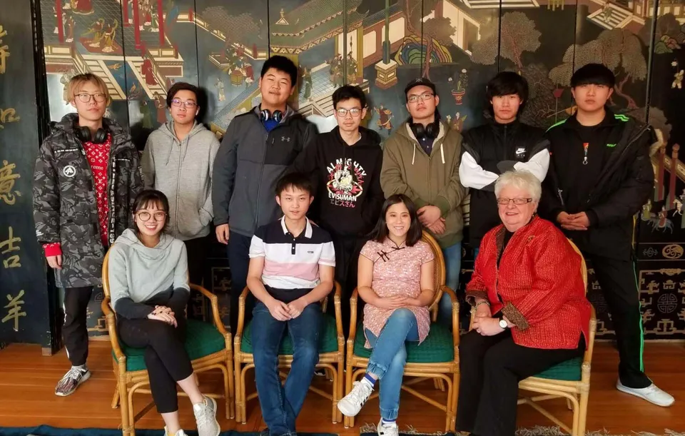 Un gruppo di studentesse e studenti si trova insieme in una sala decorativa nel campus della Accelerated School.