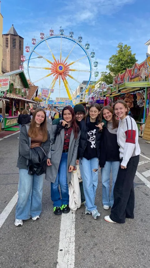 Studentesse davanti a una ruota panoramica a una fiera in Germania