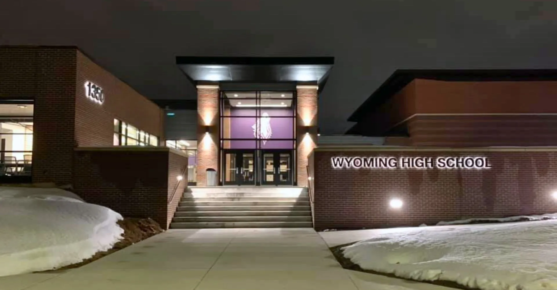 L'edificio moderno della Wyoming High School con l'area di ingresso e il piazzale innevato.