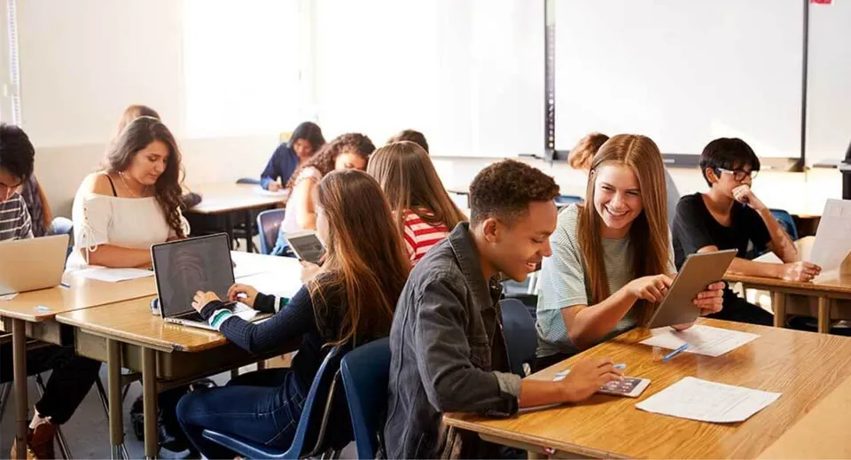 Un gruppo di studenti della The Barnes Academy siede in un'aula scolastica e lavora insieme a diversi compiti.