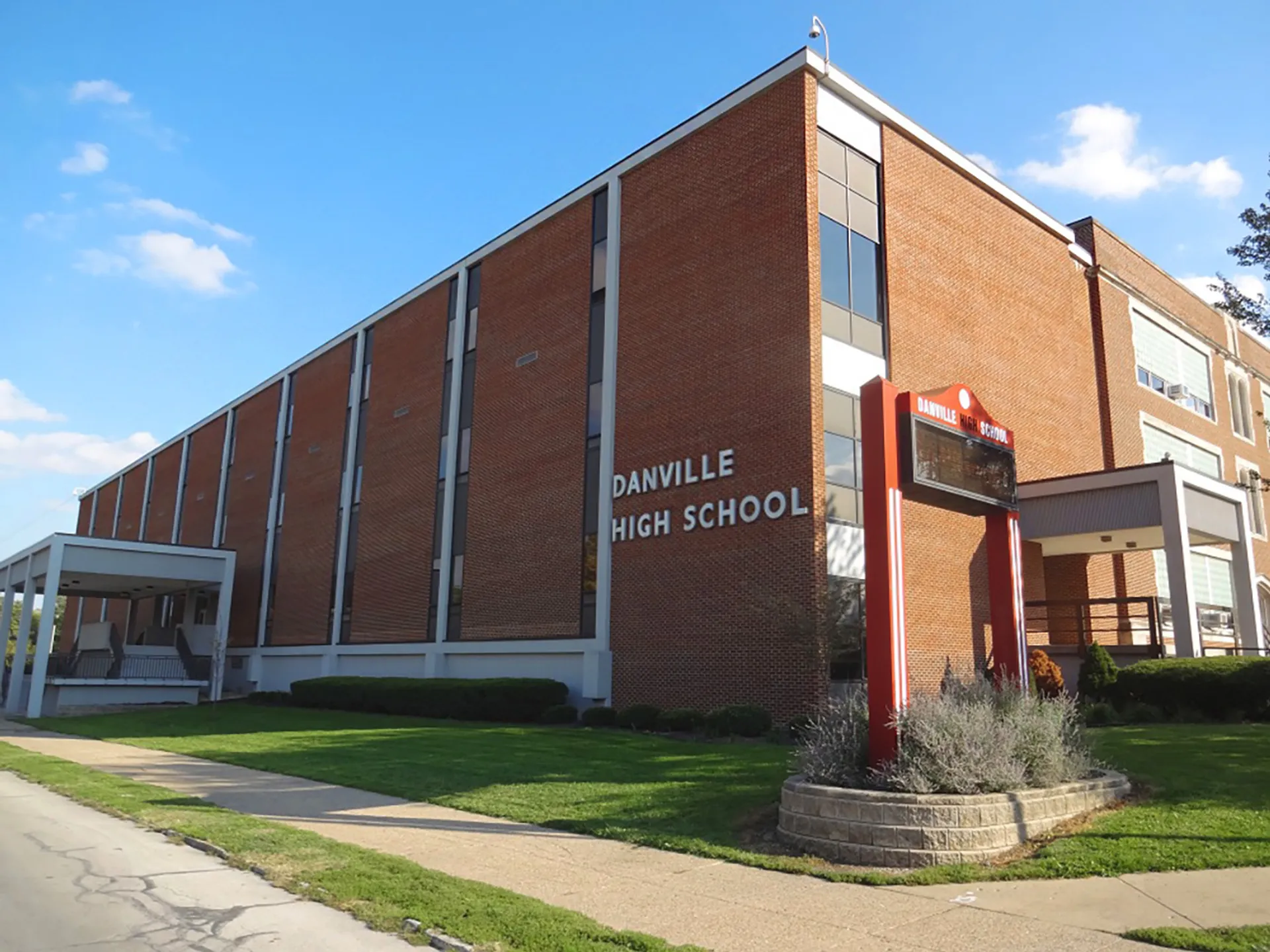Il grande edificio in mattoni della Danville Community High School è circondato da un prato curato e da spazi verdi ben progettati.