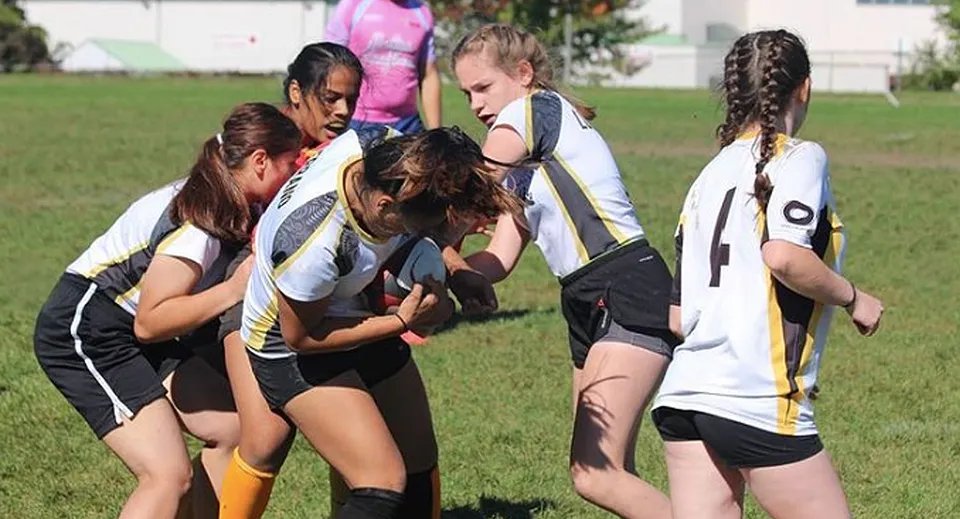 Un gruppo di giovani atlete si allena insieme sul campo sportivo della Georges Vanier Secondary School.