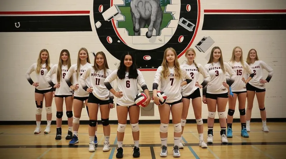 Un gruppo di giocatrici di pallavolo della Princess Margaret Secondary School è insieme nella palestra.