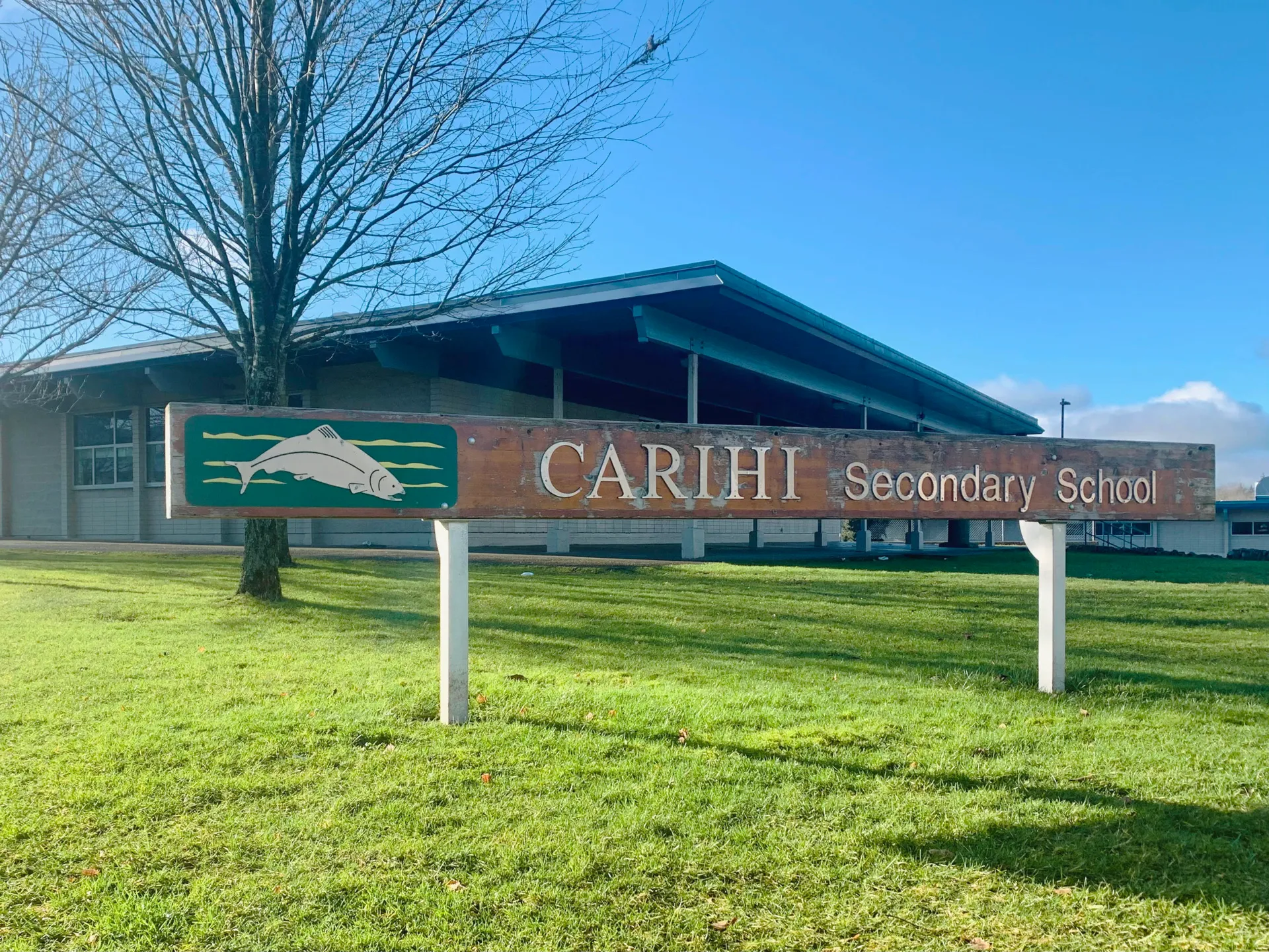 L'edificio della Carihi Secondary School si trova davanti a un prato e a un cielo blu.