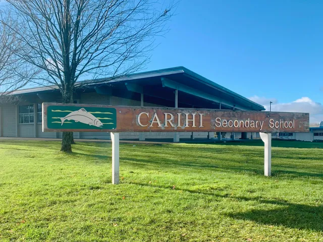 Das Gebäude der Carihi Secondary School steht vor einem Grasfeld und blauem Himmel.