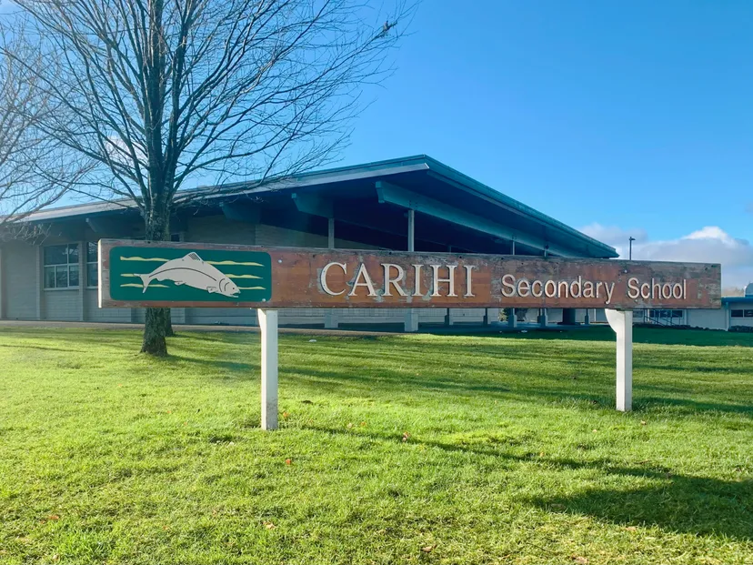 L'edificio della Carihi Secondary School si trova davanti a un prato e a un cielo blu.