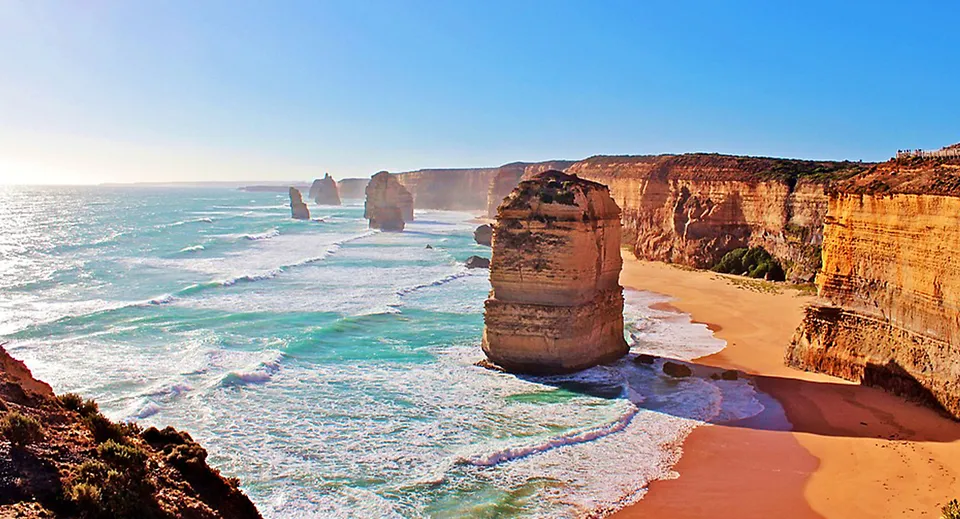 Vista sulla costa rocciosa con spiaggia di sabbia e mare turchese nei pressi della Mitchelton State High School.