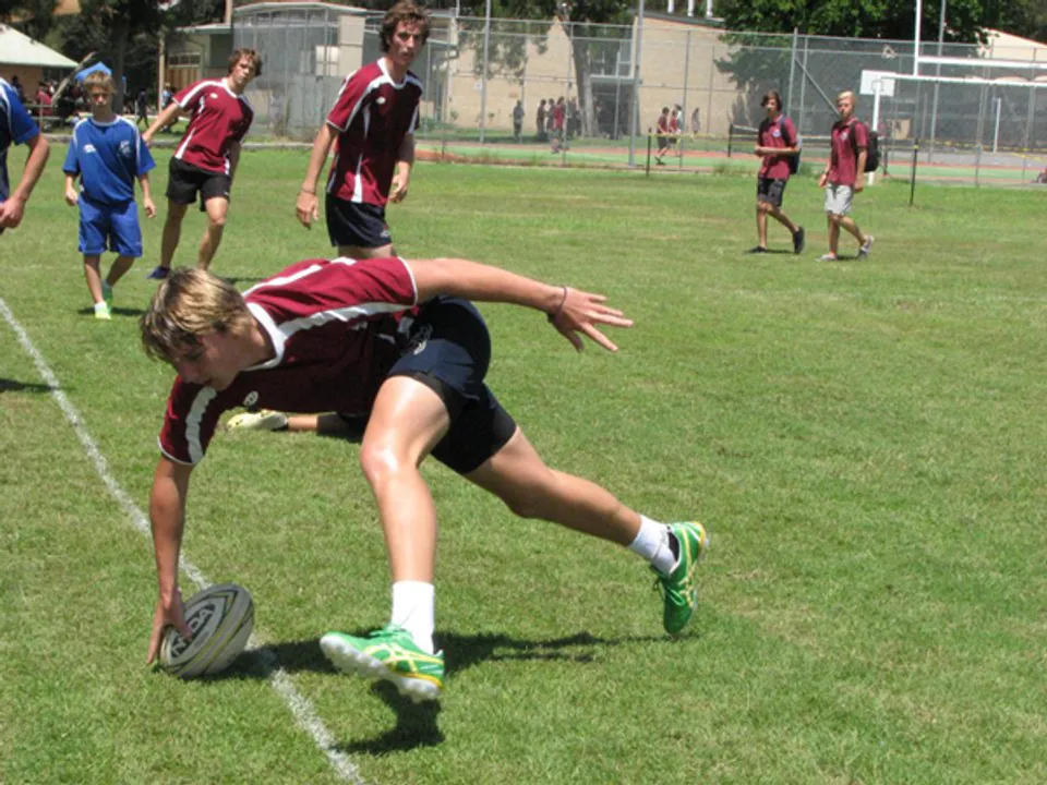 Una calciatrice della Pittwater High School si tuffa sul campo per raggiungere il pallone.