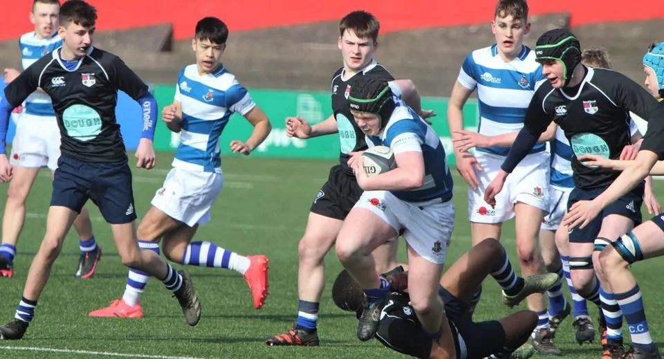 Un gruppo di giocatori di rugby gioca un'intensa partita sul campo sportivo del Rockwell College.