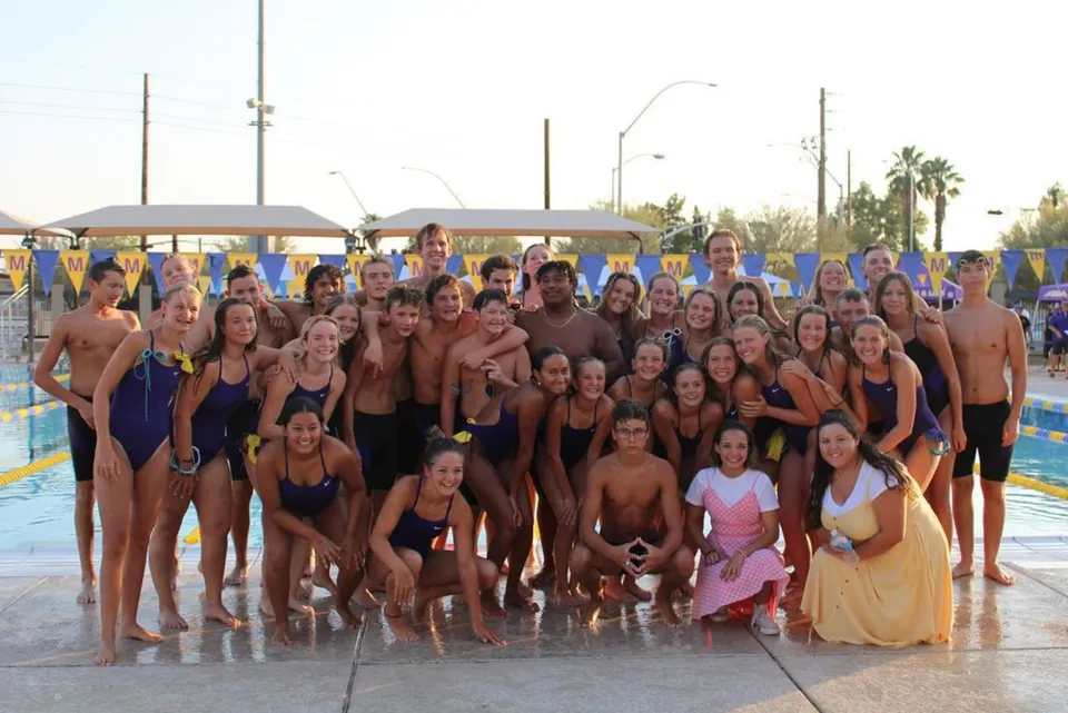 Un gruppo di studenti della Mesa High School si riunisce nell'area della piscina per una foto di gruppo.