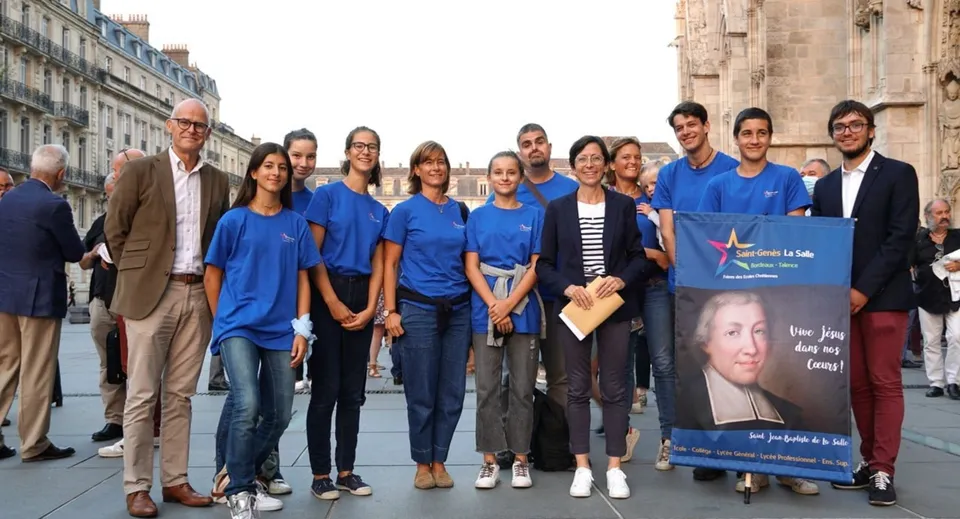 Un gruppo di studenti della Saint-Genès La Salle davanti a un edificio con uno striscione per un evento.