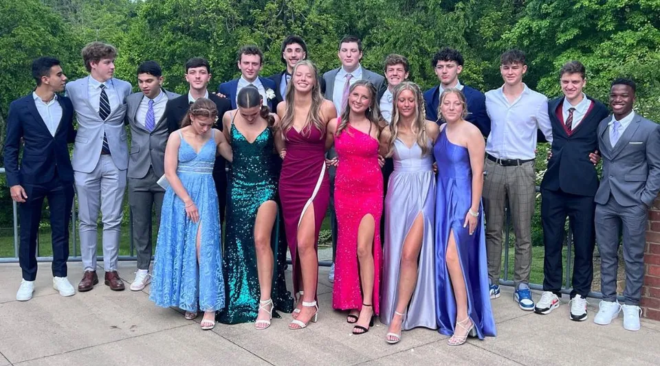 Un gruppo di studenti della Winston Salem Christian School si trova insieme in un'area verde all'aperto.
