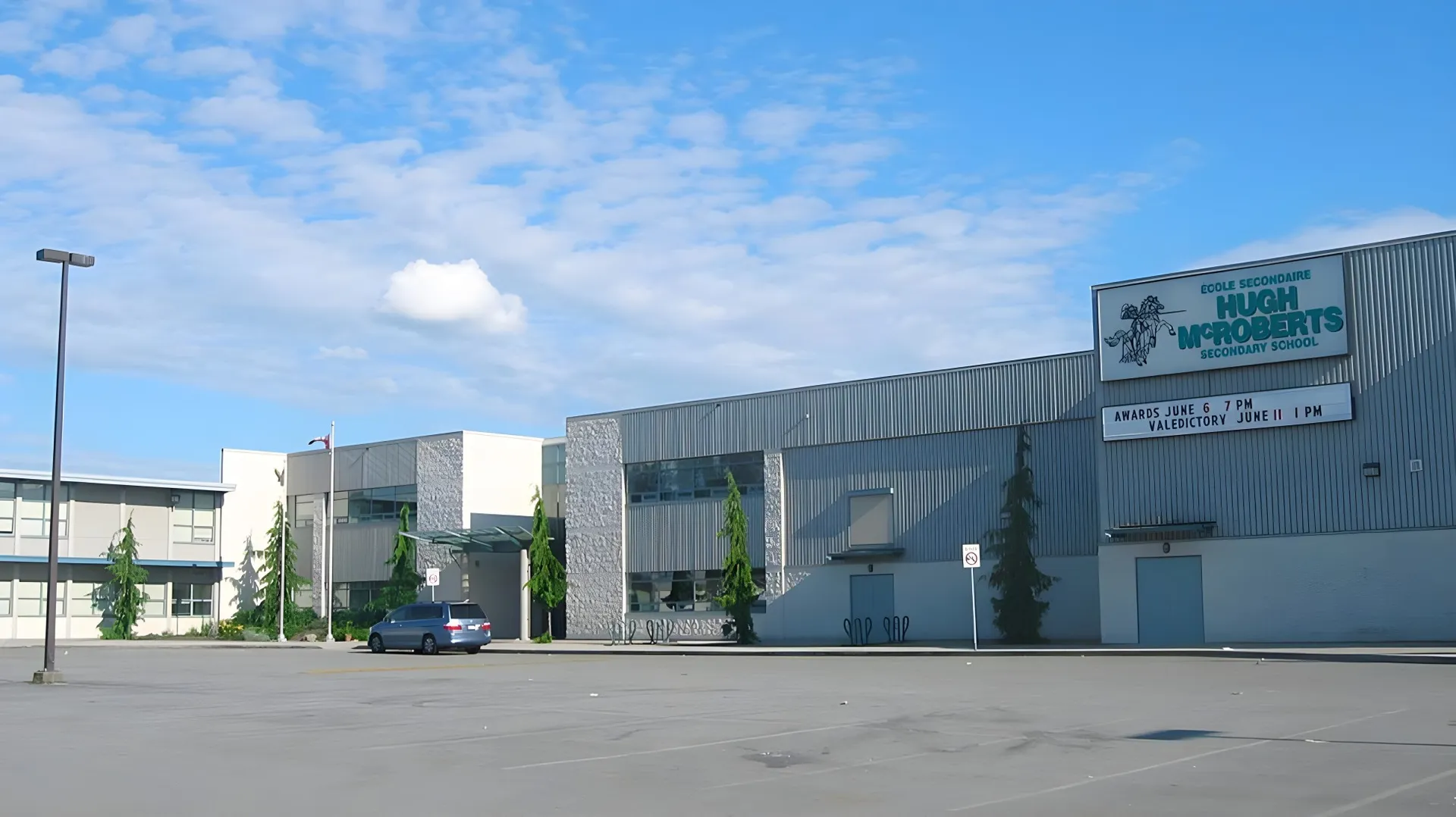 Un grande edificio industriale con un cartello Home Depot sul terreno della École Secondaire Hugh McRoberts Secondary School.