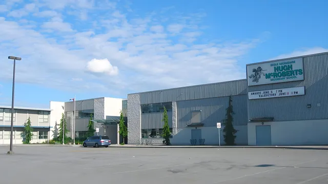Un grande edificio industriale con un cartello Home Depot sul terreno della École Secondaire Hugh McRoberts Secondary School.