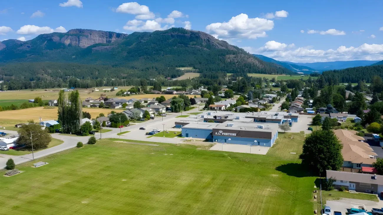 Una pintoresca pueblo montano en un valle verde frente al terreno de la A.L. Fortune Secondary School.